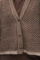 Cardigan de tejido de punto con textura, silueta boxy y cuello en V. Presenta cierre frontal con botones y detalles de terminación en contraste de color en los bordes.