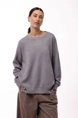 Sweater de punto con cuello redondo, mangas largas con hombros caídos y silueta relajada.