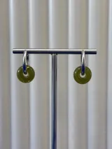 Aros tipo argolla de plata 925 con dije colgante en forma de dona de vidrio color verde musgo.