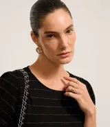 Blusa de viscosa color negro con estampado de rayas horizontales plateadas, cuello redondo y mangas cortas.