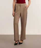 Pantalón de vestir de corte recto color beige, de cintura alta, con trabillas, cierre tradicional, pliegues y contraste lateral negro.