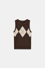 Chaleco de punto color marrón oscuro con diseño de rombos en beige y líneas azules. Tiene cuello redondo y manga sisa.