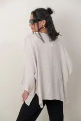 Blusa de lino color verde militar, holgada, de manga 3/4 con volados en los puños, cuello redondo y detalle de alforzas horizontales en el dobladillo.