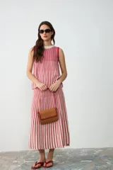 Cartera de hombro pequeña de cuero color tostado, con solapa y detalles de bordado artesanal en hilo rojo. Cuenta con correa ajustable y cierre con broches imantados.