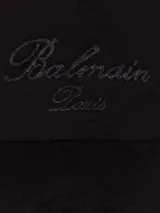Gorra negra de algodón con visera y logo Balmain bordado en el frente.