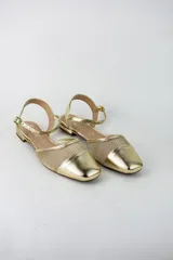 Sandalias planas color dorado, con puntera cerrada, diseño combinado con tela tipo red y tira ajustable al tobillo con hebilla.