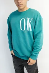 Buzo oversize verde inglés con estampa frontal con la frase "It's OK, don't worry" en color blanco.
