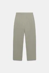Pantalón de tiro alto con diseño tipo barrel, presenta pliegues frontales pronunciados, bolsillos laterales y cierre frontal con cremallera, botón interior y gancho metálico oculto.