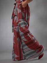 Mono de lino mezcla con estampado vegetal en tonos rojos, grises y blancos, de manga corta, escote en V y piernas amplias con cinto incorporado para ajustar la cintura.