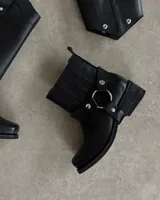 Bota de cuero negra con caña alta y estribo desmontable.