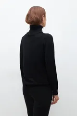 Polera negra de cuello alto y manga larga.