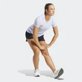 Remera de running Adidas Adizero Essentials color lila con logo naranja en el pecho y paneles laterales de malla.