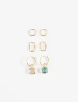 Set de tres pares de aros dorados. Incluye un par de argollas lisas pequeñas, un par de argollas rectangulares tipo mosquetón y un par de argollas con dijes de piedra cuadrada en tonos transparente y turquesa.