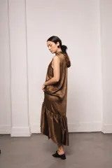 Vestido largo color ocre con estampado de cuadrados dorados, cuello alto y corte amplio. Incluye viso liso al tono.