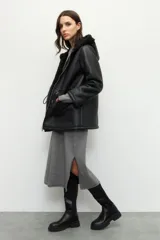 Campera tipo gamulán de cuero sintético negro con interior forrado en corderito sintético. Presenta capucha, cierre frontal con cremallera, bolsillos frontales tipo parche y cordones ajustables en la cintura.