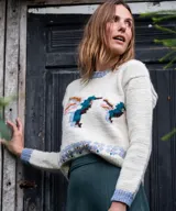 Sweater de lana merino color natural tejido en punto jersey, con diseño jacquard multicolor de aves en el frente y detalles en tono celeste en cuello, puños y ruedo.