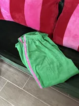 Pantalón de jogging tipo track de plush color verde, con cintura elástica y franja lateral de terciopelo en color rosa.