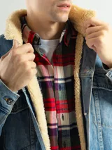 Campera de jean celeste con cuello de corderito color crema, cierre con botones metálicos, bolsillos frontales con solapa y puños abotonados.