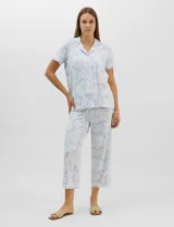 Conjunto de pijama de tres piezas en color celeste con estampado floral blanco y detalles de puntilla de encaje. Incluye una musculosa de breteles finos con escote en V, un capri con cintura elástica y cordón ajustable, y una camisa a juego.