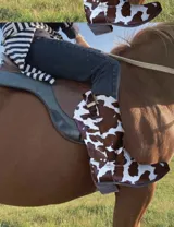 Botas de cuero color marrón y blanco con bordados negros, de estilo cowboy con taco bajo.