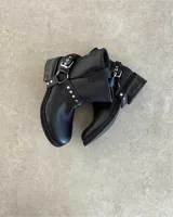 Botín de cuero vacuno negro de caña corta con hebilla y tachas plateadas.