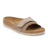 Sandalias Birkenstock modelo Oita en color taupe, con diseño de una sola correa ancha ajustable mediante velcro y detalles de remaches metálicos. Presentan la clásica plantilla anatómica de corcho y látex con recubrimiento de gamuza y suela de EVA.