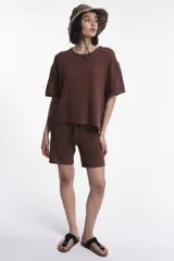 Top de tejido de punto color marrón, con cuello redondo y mangas cortas de corte holgado.