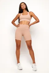 Conjunto deportivo de mujer compuesto por un top de diseño nadador y un biker de tiro alto. Ambas prendas son de color negro, confeccionadas en poliamida de alta performance con detalles reflectivos, bolsillos funcionales y recortes estratégicos para mayor comodidad y ajuste durante el entrenamiento.