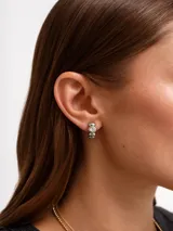 Aros abridores de acero plateado con diseño de esferas en relieve y una pequeña piedra brillante engastada en el centro.