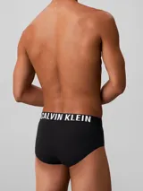 Pack de tres slips Calvin Klein de color negro, confeccionados en mezcla de algodón y elastano, con cintura elástica distintiva de la marca con logotipos en color gris, blanco y azul.