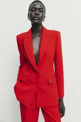 Blazer entallada de cuello solapa y manga larga con hombreras. Presenta bolsillos con solapa en el delantero, forro interior a contraste y cierre frontal con botones forrados.
