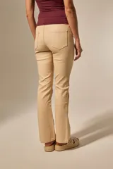 Pantalón negro de efecto cuero, tiro medio, con corte recto y ligeramente acampanado en la parte inferior.