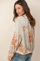 Campera liviana de satén con estampado floral y tropical, cierre frontal con cremallera, cuello mao y puños y cintura elásticos.