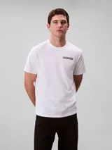 Remera de algodón regenerativo Calvin Klein de color blanco, con cuello redondo, mangas cortas, corte regular y el logo de la marca en gráfico 3D en el pecho.