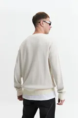 Buzo de punto oversize color negro, con escote redondo y puños.