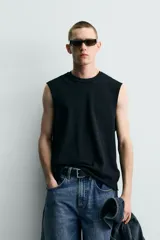 Camiseta tank de punto de algodón, color negro, de corte relaxed fit con cuello redondo, manga sisa y acabados irregulares.