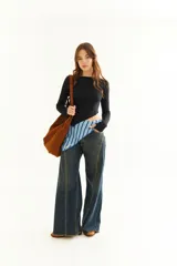 Top de manga larga color blanco, confeccionado en tejido de punto acanalado con diseño irregular y aberturas para los pulgares en los puños.