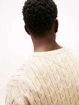 Sweater Tommy Hilfiger de punto trenzado color beige, con cuello redondo, mangas largas y puños y bajo de canalé. Incluye logo bordado en el pecho.