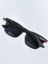 Lentes de sol con armazón de color gris mate y detalles en azul en las patillas. Cuentan con cristales oscuros polarizados y protección UV 400.