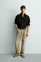 Pantalón de jean estilo straight fit, de corte recto y tiro medio, con efecto lavado en color gris oscuro. Cuenta con diseño clásico de cinco bolsillos y cierre frontal con botones.