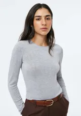 Blusa de punto gris claro melange, de tejido liviano, corte ajustado al cuerpo, cuello redondo y manga larga.