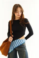 Top de manga larga color negro, con diseño asimétrico y corte irregular en el ruedo.