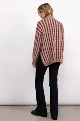 Sweater de tejido de punto con diseño de trenzas verticales, cuello alto, manga larga y silueta oversize de largo extendido.