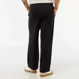 Pantalón de corte ancho y tiro medio, confeccionado en algodón de color negro, con diseño liso y bolsillos laterales.