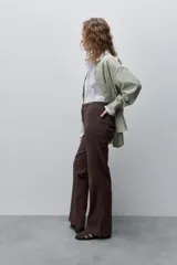 Pantalón de jean azul marino, de tiro alto y calce ajustado con pierna recta levemente amplia, bolsillos traseros y recortes verticales en el delantero.
