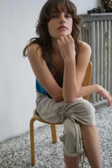 Pantalón capri de tiro medio con efecto lavado, bolsillos delanteros y traseros, y bajo con frunces laterales ajustables mediante cordones.