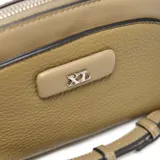 Bandolera color verde de material símil cuero (PU) con textura granulada. Diseño redondeado con cierre superior metálico y logo XL aplicado al frente. Incluye correa regulable y desmontable.