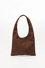 Cartera tipo hobo confeccionada en gamuza negra, con asa integrada y decorada en toda su superficie con tachas metálicas plateadas dispuestas en patrones geométricos.