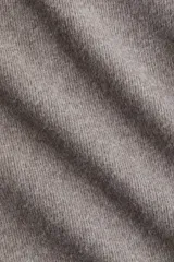 Top de punto fino color gris, con cuello redondo, hombros caídos, mangas al codo y costuras decorativas verticales en el frente que le dan un bajo levemente acampanado.