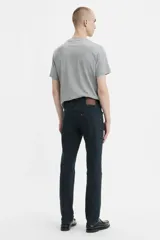 Jean de corte slim fit con tiro medio, confeccionado en denim de color negro con acabado desgastado.
